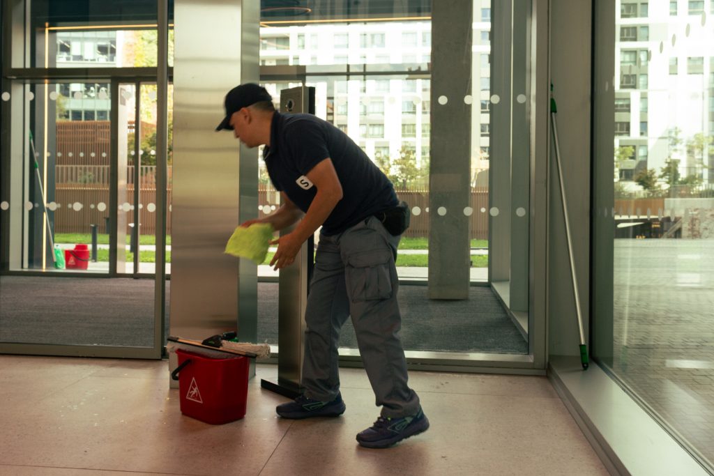 Persona limpiando en un edificio moderno.